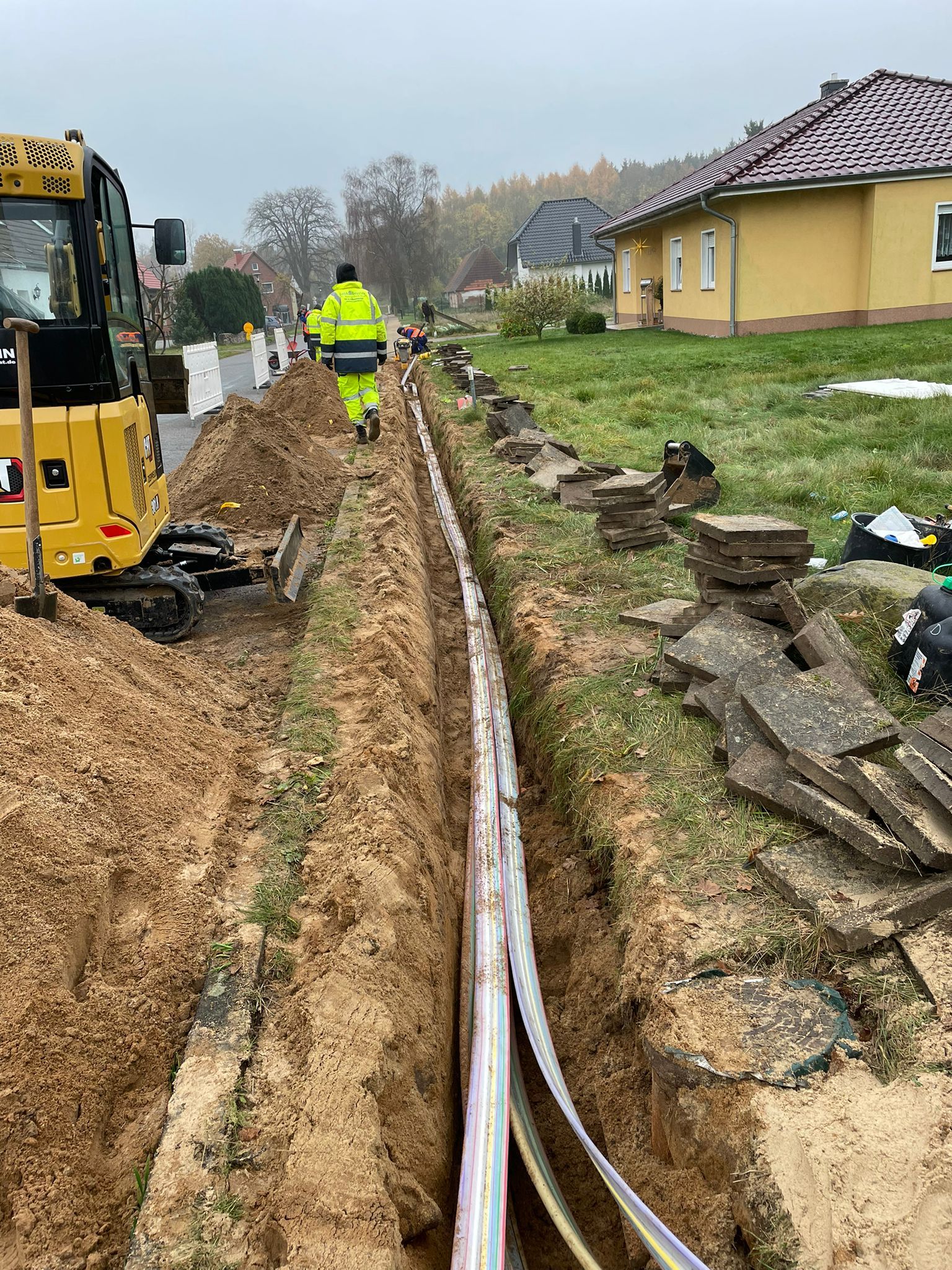 Mitarbeiter und Baufahrzeuge der GeBA Baustein GmbH bei Bau und Verlegearbeiten von Glasfaserkabeln