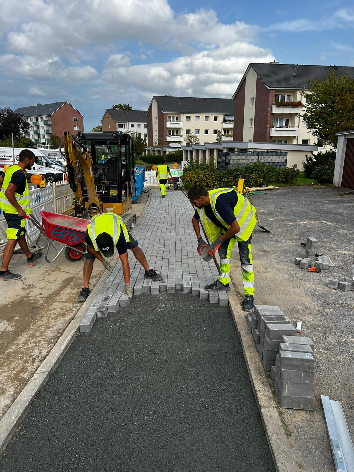 Mehrere Mitarbeiter der GeBA Baustein GmbH bei Pflasterarbeiten